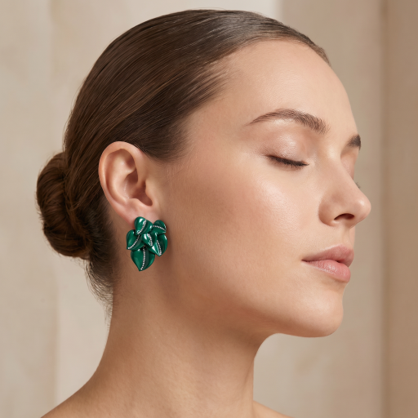 Green titanium leaf stud earrings, designer botanical earrings, contemporary luxury titanium jewellery on model.
