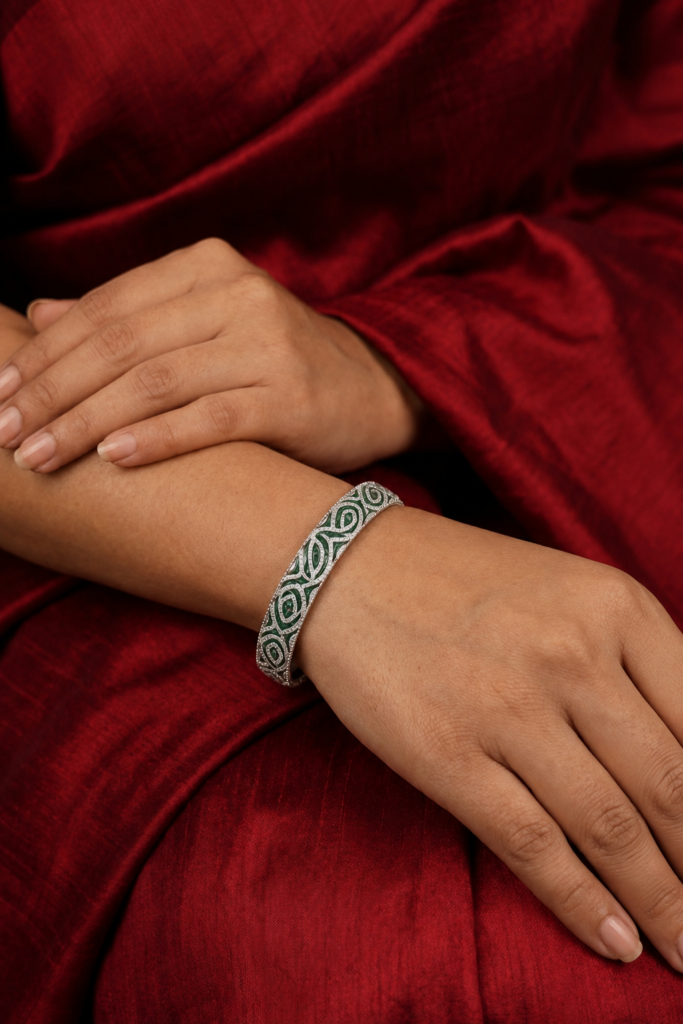 18K gold emerald and diamond bangle featuring green enamel accents, intricate geometric patterns, and a contemporary luxury design.
