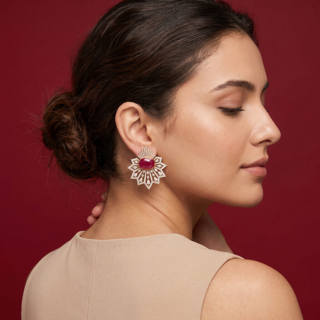 Ruby and diamond statement earrings featuring a bold geometric floral design with a vivid oval ruby centre and brilliant diamond detailing.