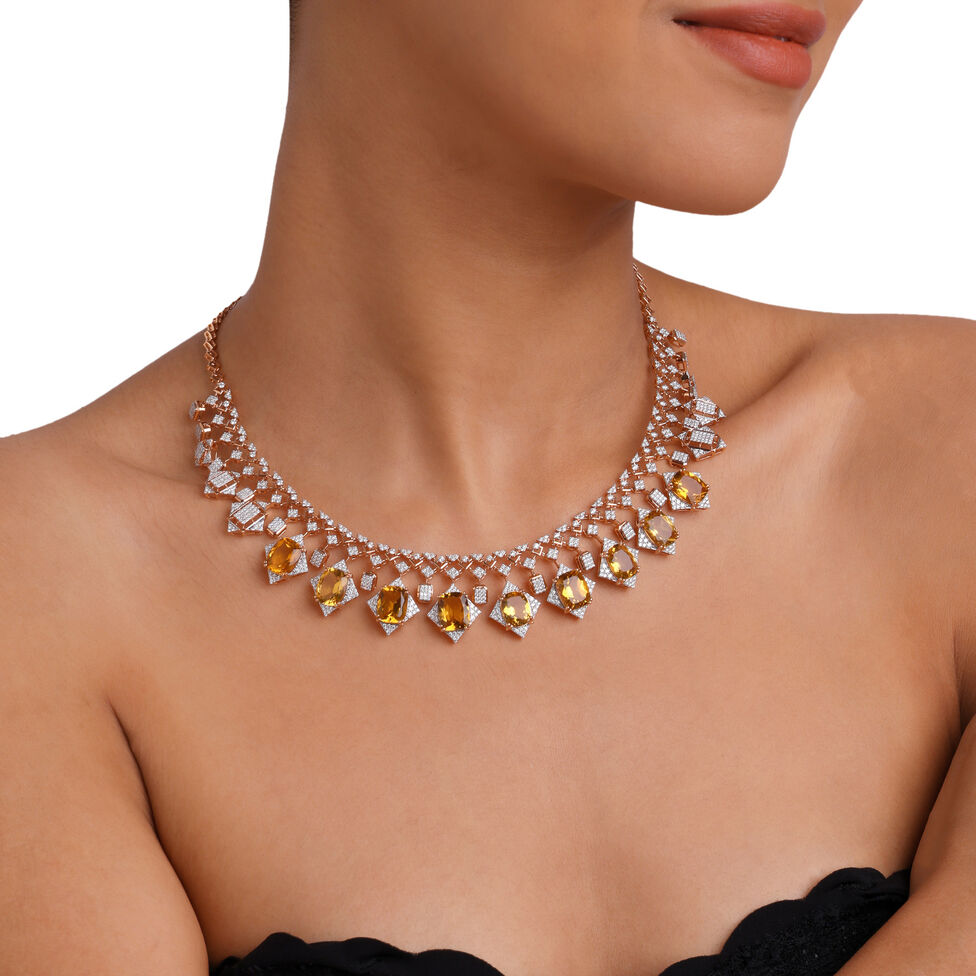 Diamond necklace with warm yellow gemstones styled on a model
